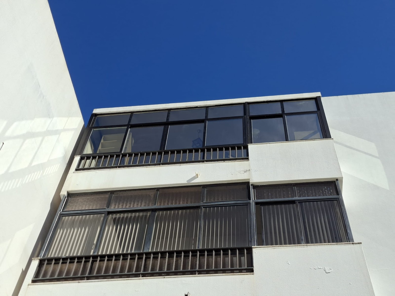 Estrutura comercial com caixilharia preta e gradeamento