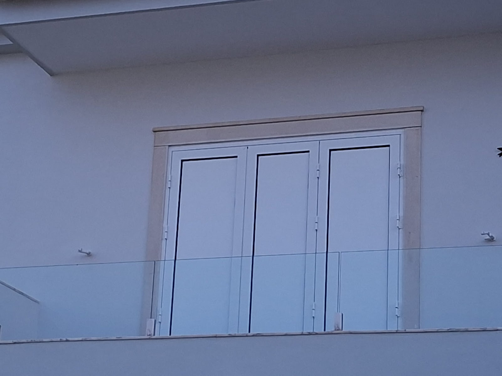 Fachada de apartamento com porta de fole branca